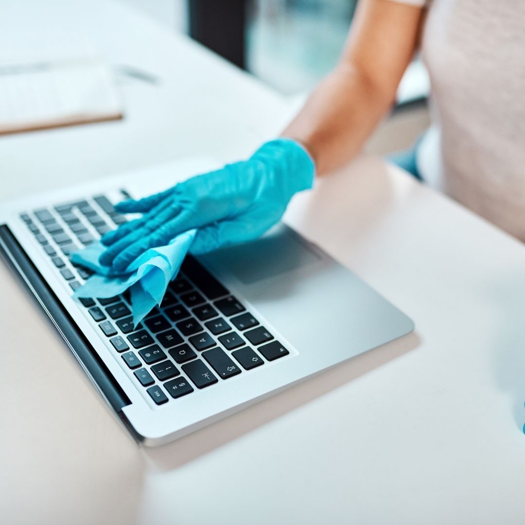 gloved hand wiping keyboard